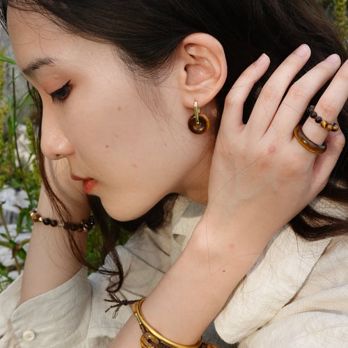 Woman wearing Tiger's eye and gold jewelry.